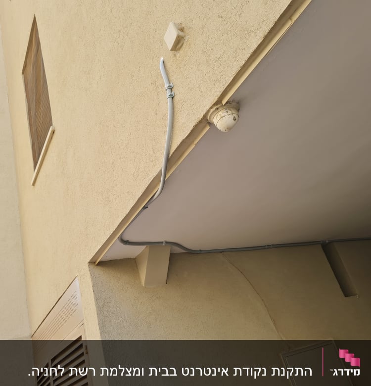 כבל תקשורת מחובר לקיר עם מצלמת אבטחה